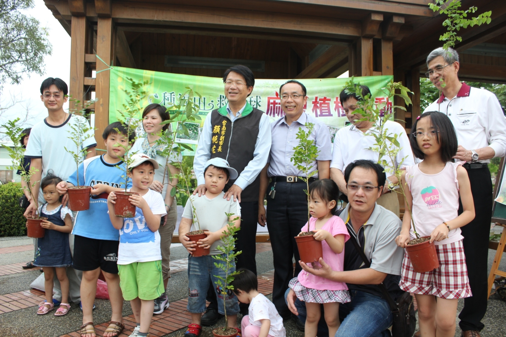 小朋友帶著自己親自種植的樹苗與本會執行長、顏副市長合影